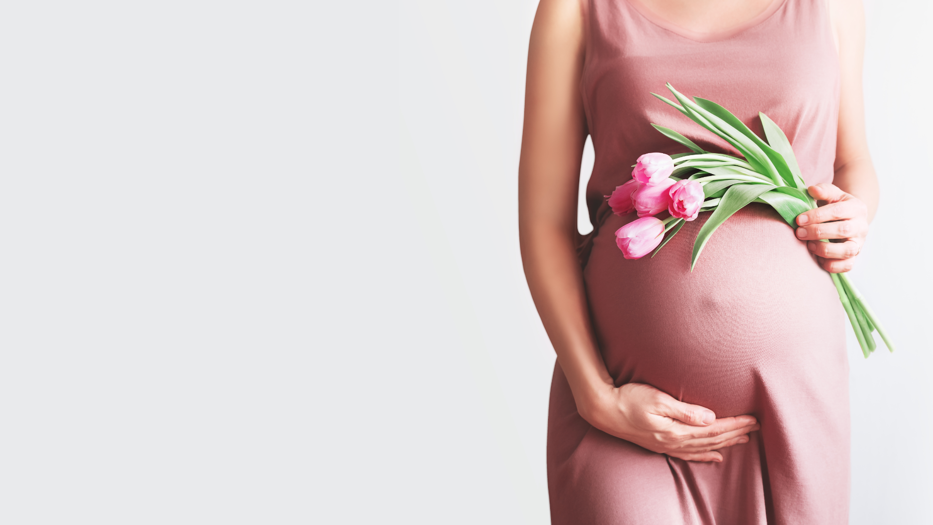 Woman cradling her pregnancy, bathed in warm natural light